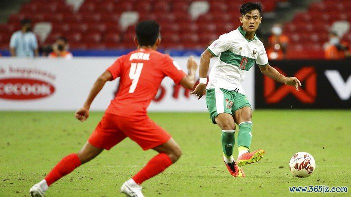 Pratama Arhan Alif Rifai of Indonesia, right, makes a pass during the AFF Suzuki Cup 2020 semi-final first leg match between Singapore and Indonesia in Singapore, Wednesday, Dec. 22, 2021. (AP Photo/Suhaimi Abdullah)